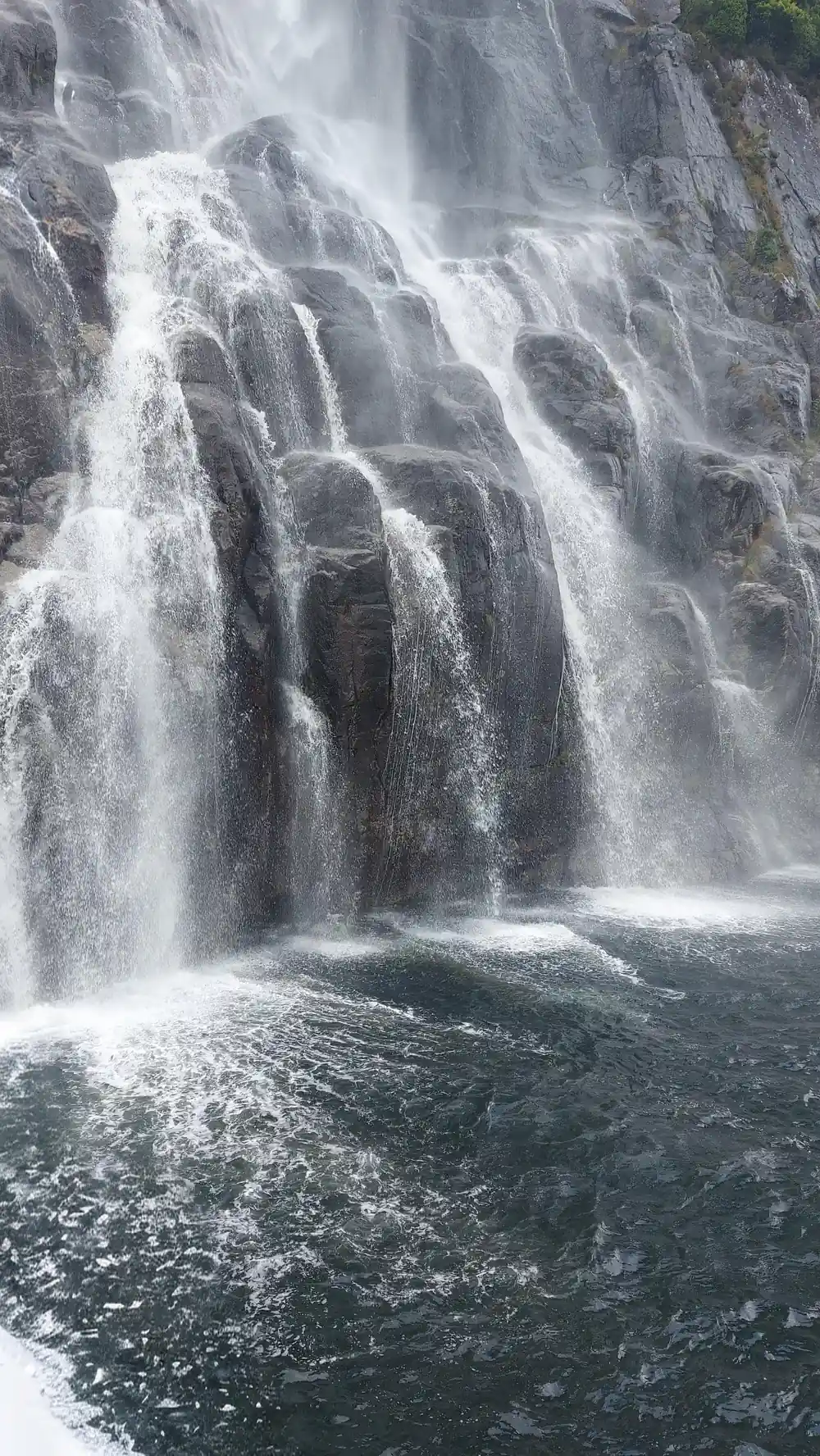 Multiple waterfalls cascading down columnar rock face