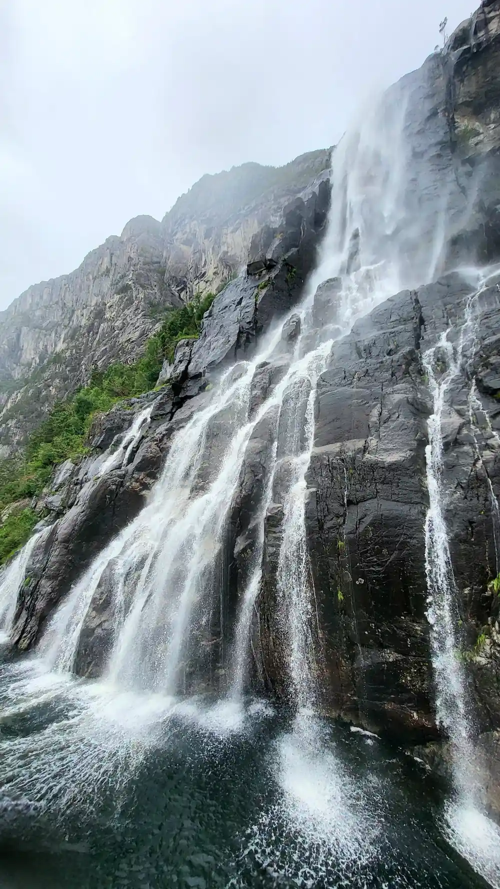 Multiple waterfalls cascading down rocky cliff face