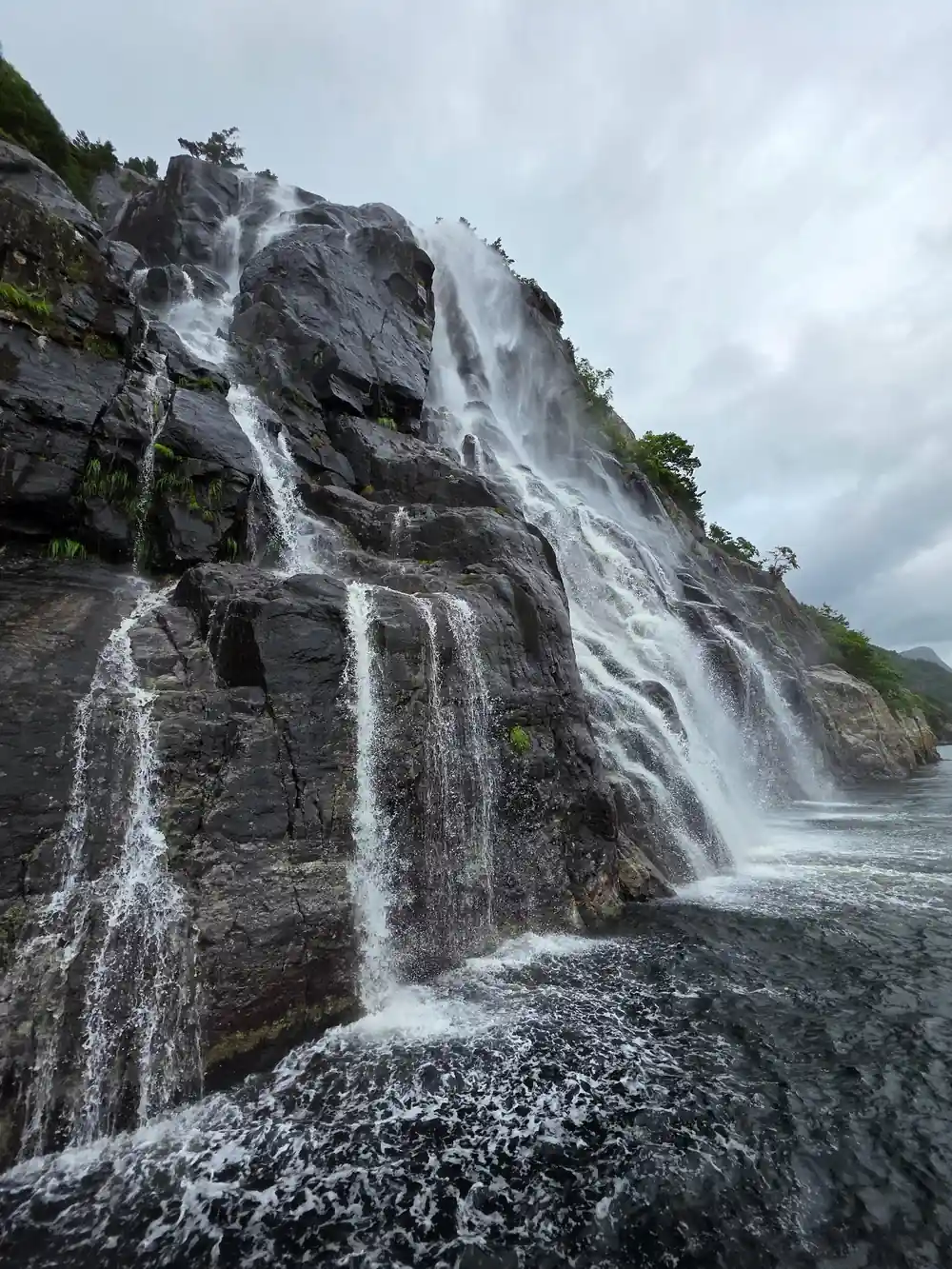Multiple waterfalls cascading down rocky cliff face