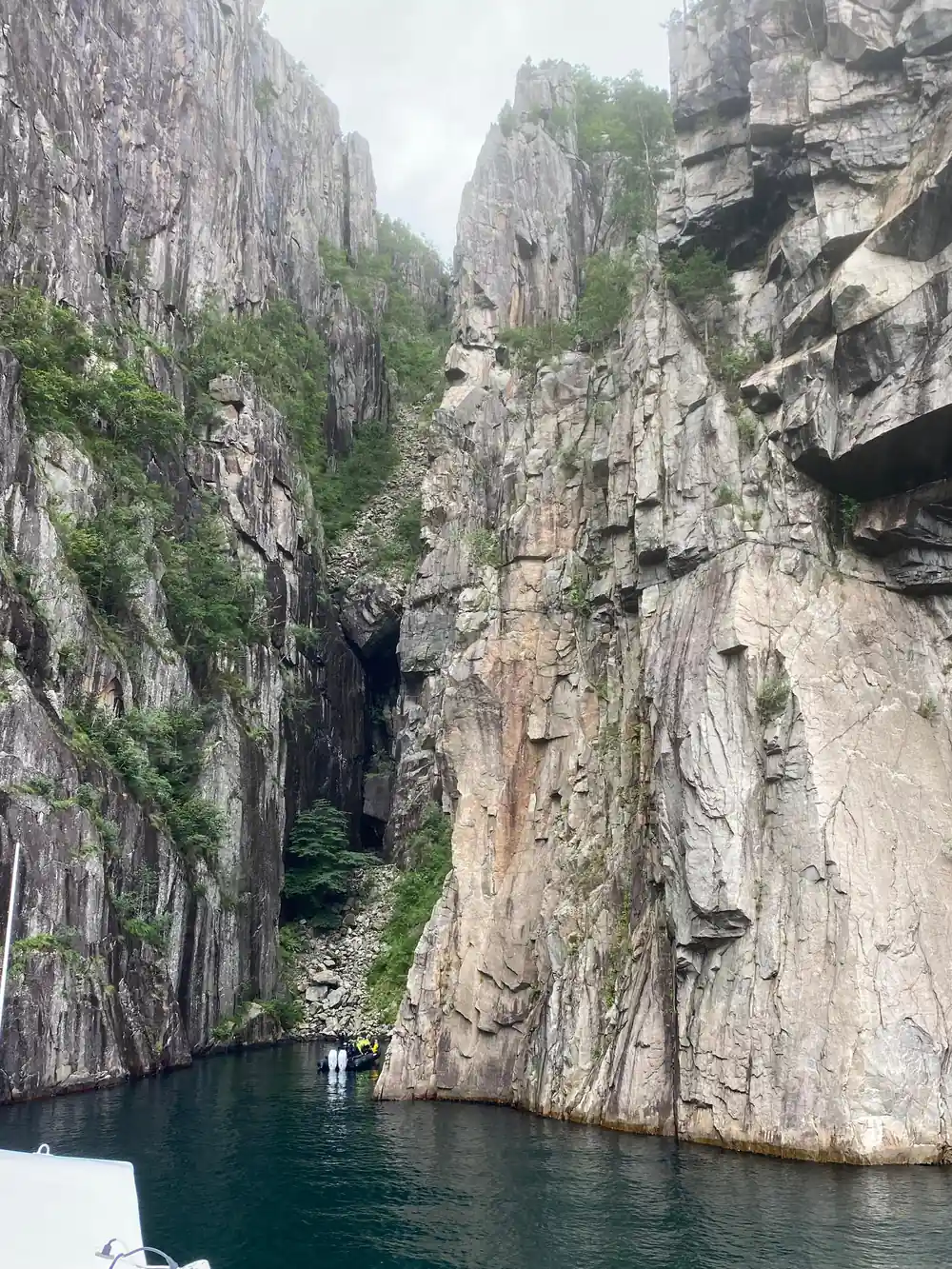Narrow fjord between tall vertical cliff faces with water