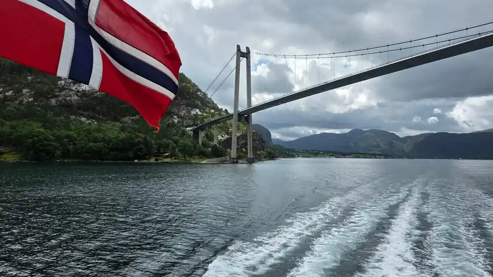 Norwegian flag on ferry with suspension bridge visible