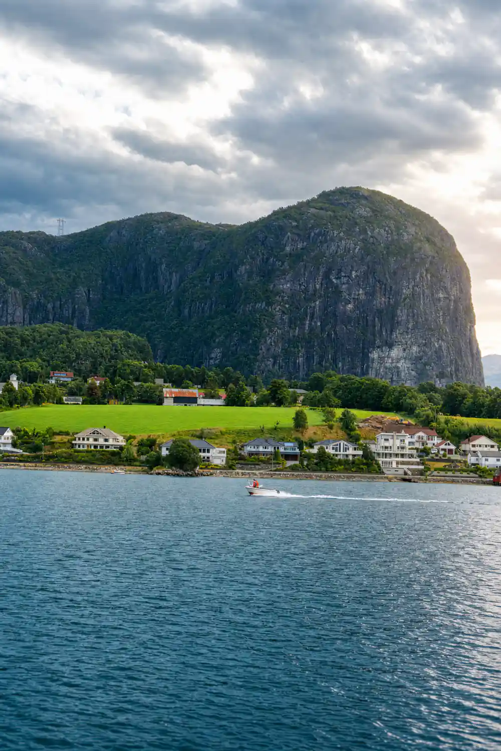 Rural village nestled at base of massive steep mountain