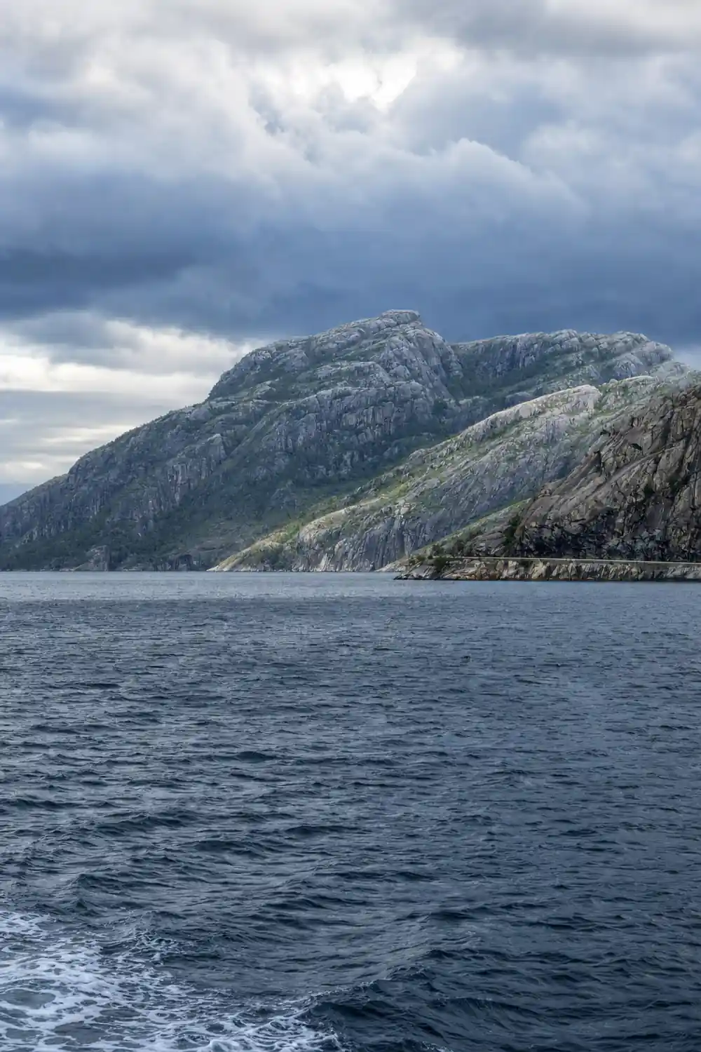 Steep mountain with vertical rock columns rising from sea
