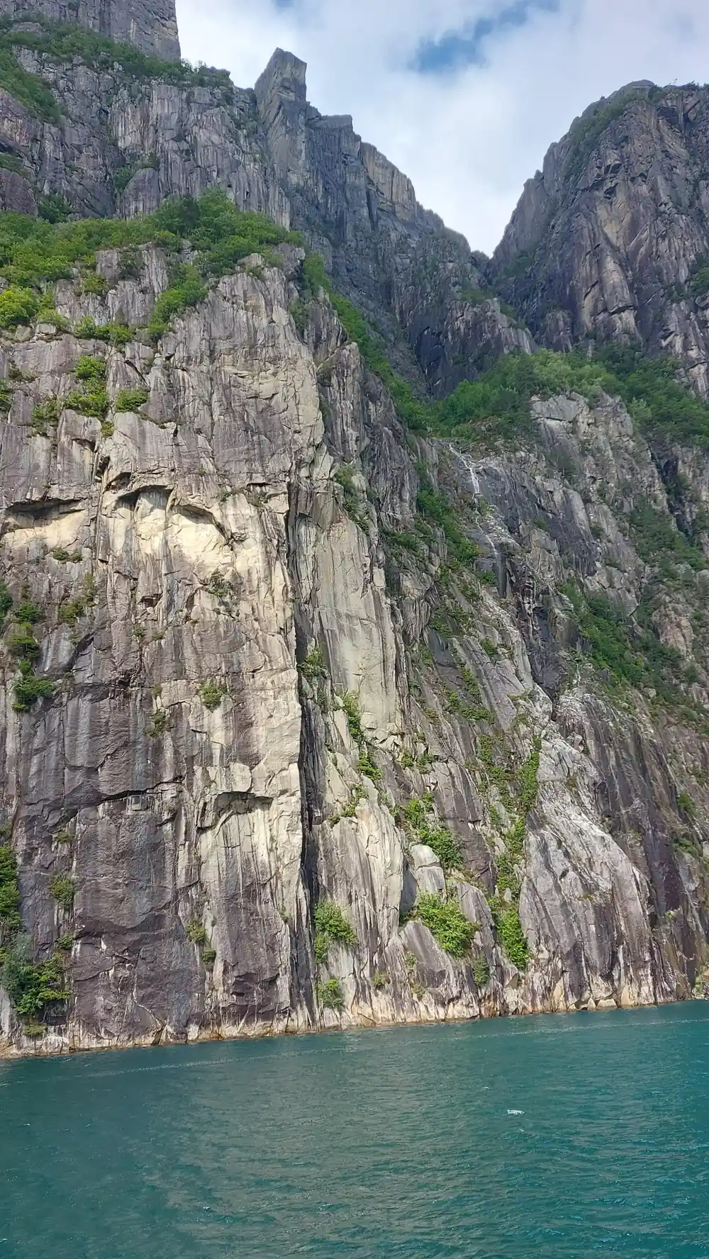 Steep rocky fjord walls framing turquoise water channel