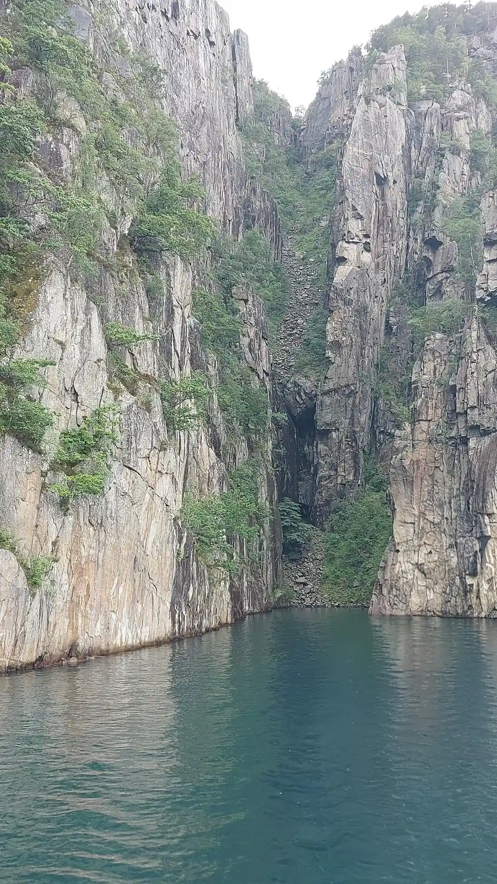 Steep rocky fjord walls with turquoise water below