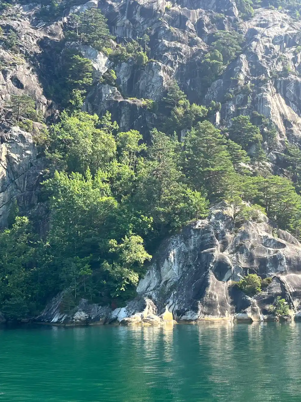 Turquoise water and green vegetation on steep cliff